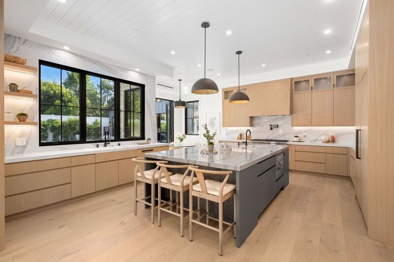 Comedor en centro de cocina moderna cubierta con madera en tono claro.